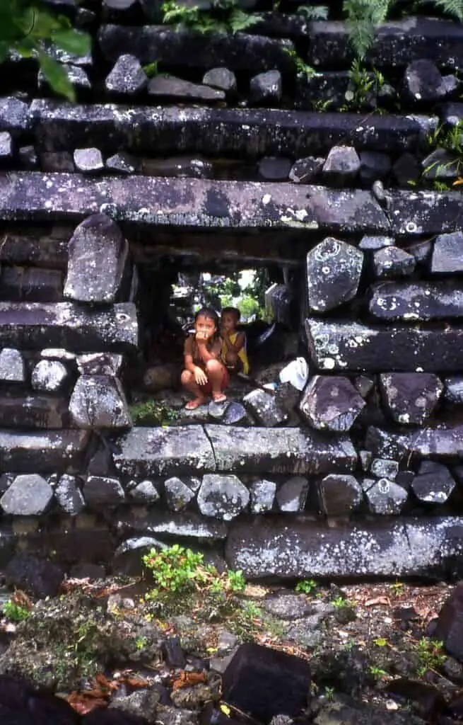 Kids in Passage Through Basalt Wall Nan Madol Pohnpei